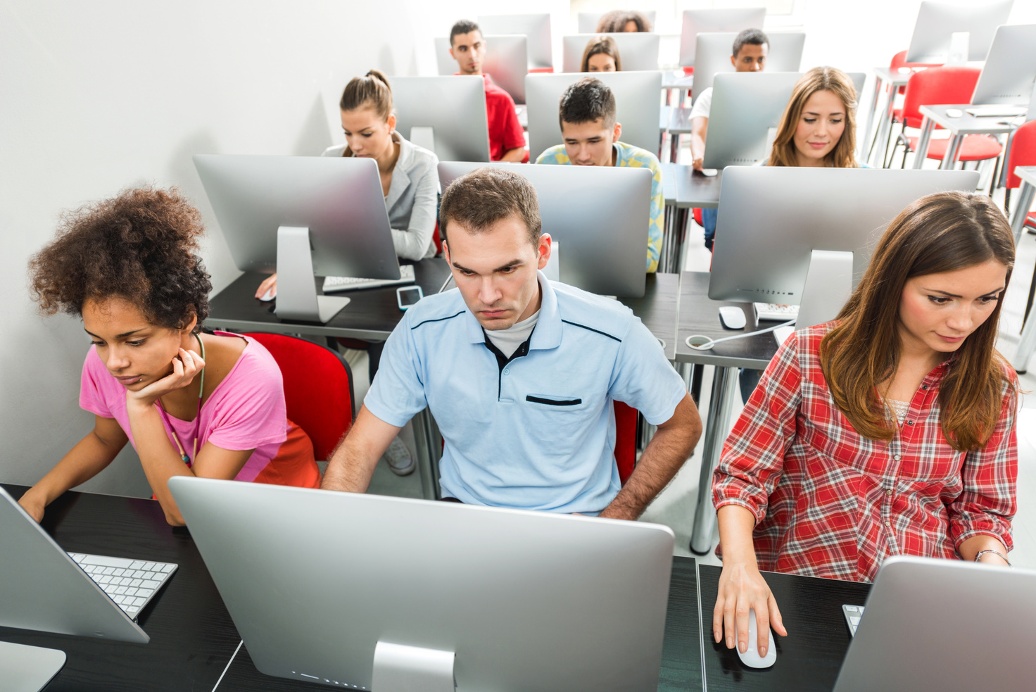 Large group of people using computer in a computer lab.